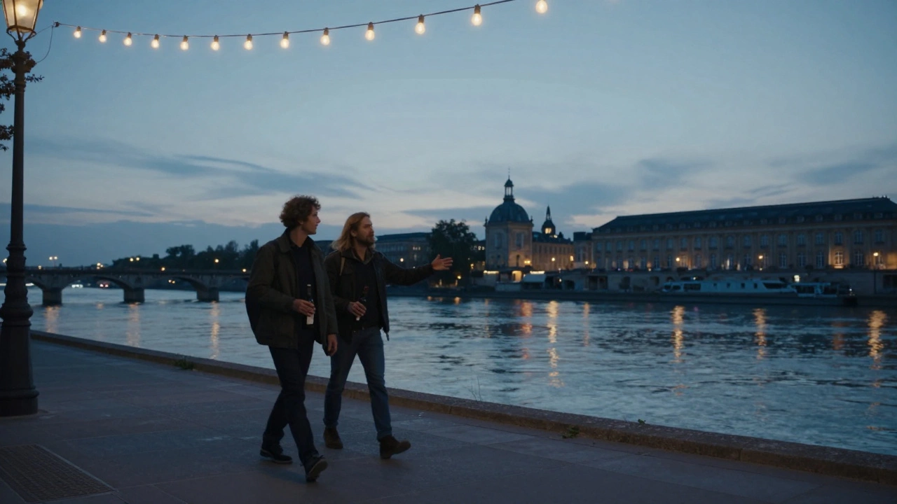 Two people walking peacefully along the Garonne River at twilight in Bordeaux.